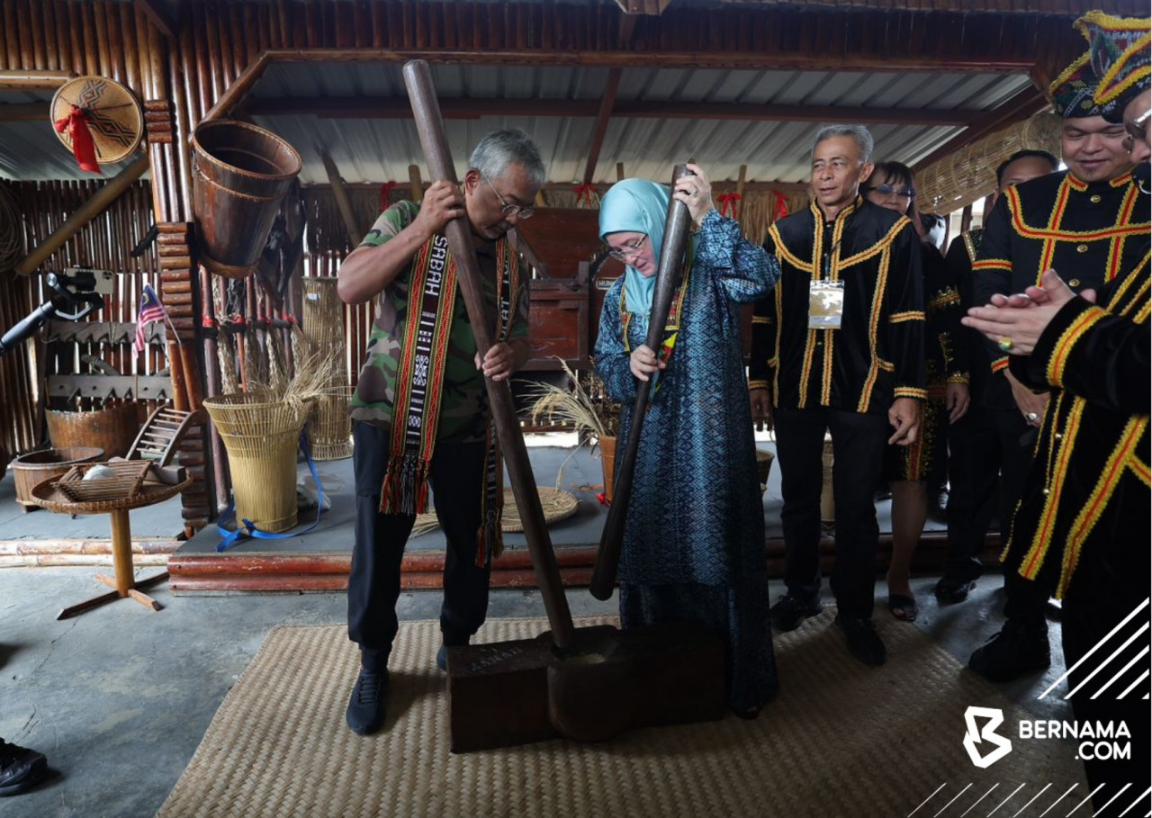 Al-Sultan Abdullah Ri'ayatuddin Al-Mustafa Billah Shah dan Tunku Azizah Aminah Maimunah Iskandariah berkenan mencuba menumbuk menggunakan lesung dan antan di Kompleks Persatuan Kebudayaan Kadazandusun (KDCA). - gambar BERNAMA