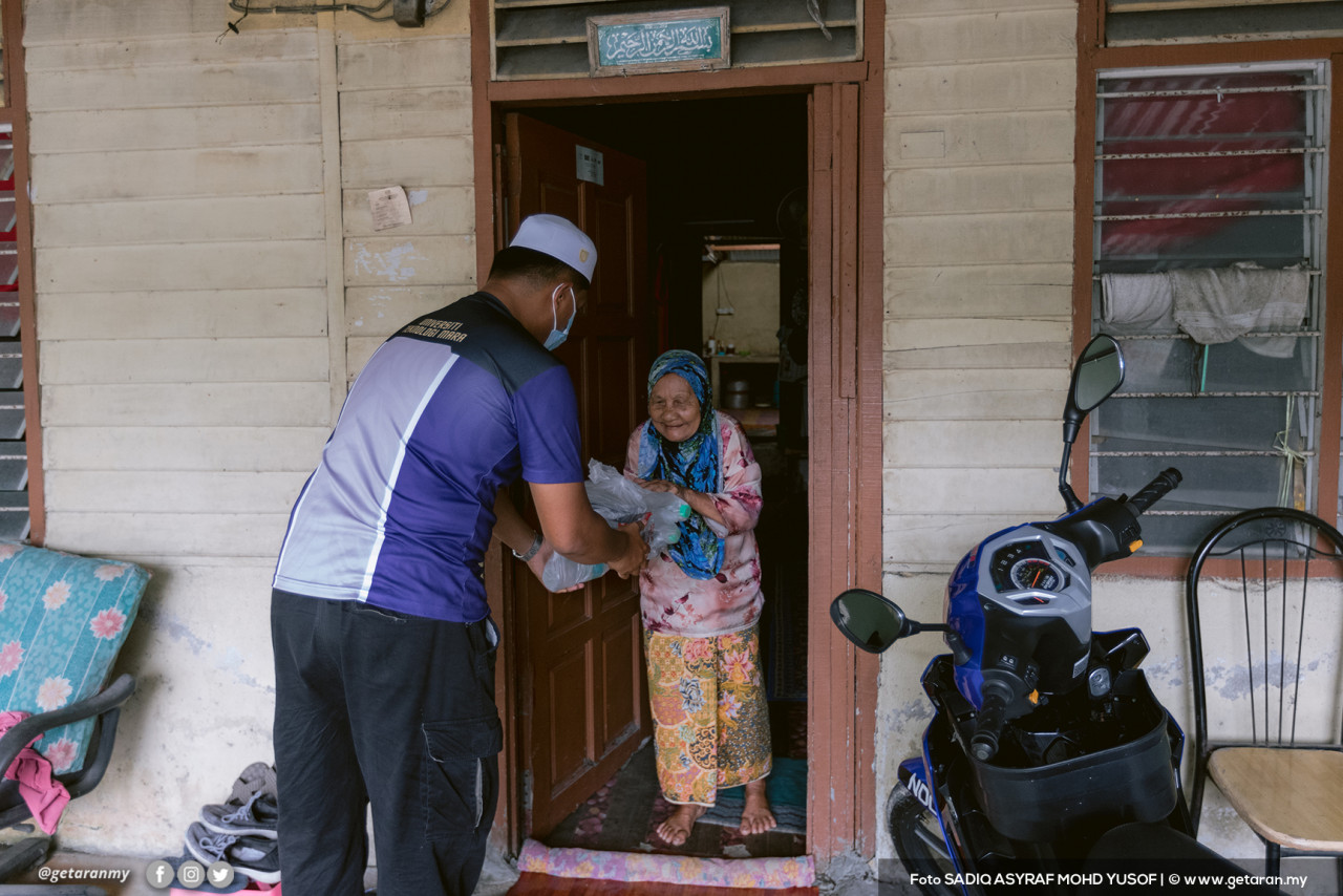 Wan Razmi menyampaikan sumbangan kepada golongan asnaf di sekitar kediaman mereka di Batu 11, Gombak.