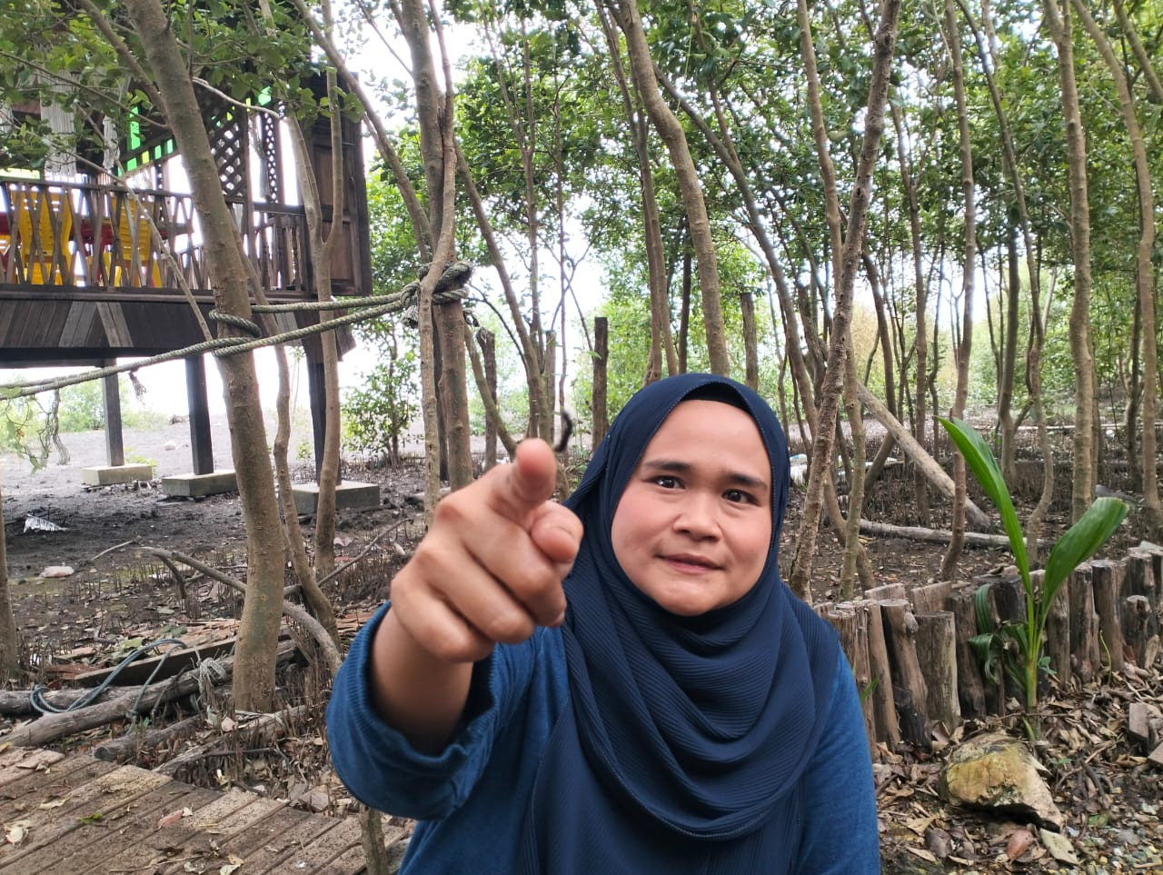 Zalilah Had menunjukkan ulat yang bergantungan ibarat labah-labah dari pokok api-api di hutan bakau berhampiran restoran diusahakannya. - gambar Rafisqi Radhi