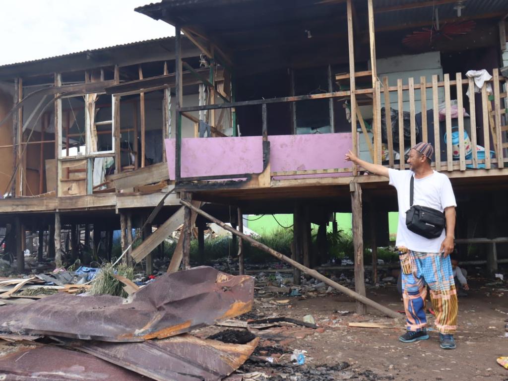 Albani menunjukkan bahagian rumahnya yang terpaksa dipecahkan bagi mengelak api terus merebak ke rumah lain.