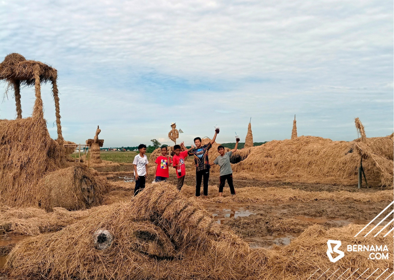 Kanak-kanak melihat arca jerami yang terdapat pada Karnival DíBendang Melaka di Kampung Parit Putat Benteng, Sungai Rambai. gambar BERNAMA