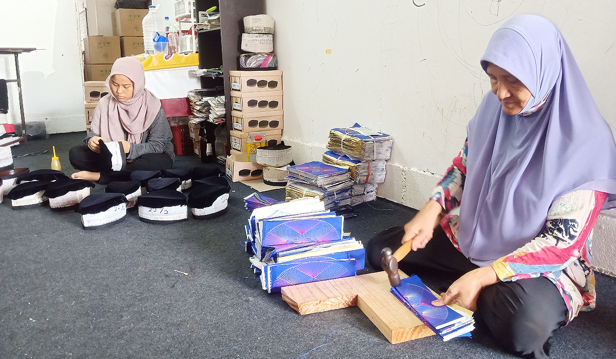 Norwahida dibantu oleh ibu dan pekerjanya untuk menghasilkan songkok jenama ZW.