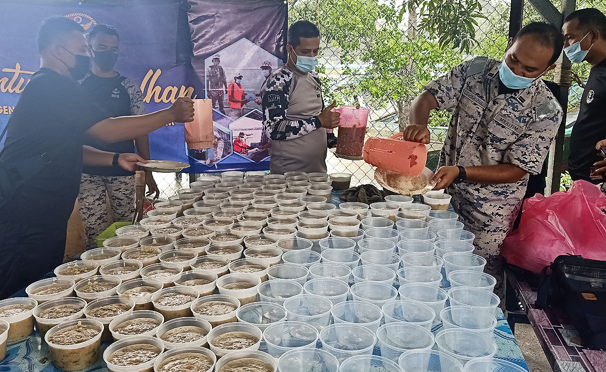 Kakitangan APMM Tawau menyediakan bubur lambuk secara gotong-royong.