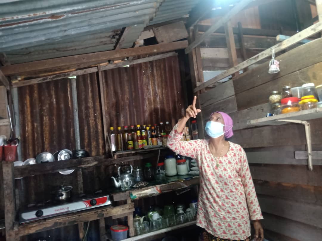 Che Zainab menunjukkan bumbung rumahnya yang bocor.