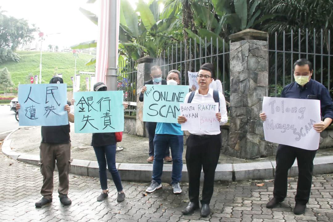 Chean Chung (dua kanan) bersama antara peserta kumpulan yang hadir di hadapan Parlimen hari ini untuk menggesa Zafrul bertindak terhadap isu penipuan kewangan dalam talian memandangkan ia semakin berleluasa