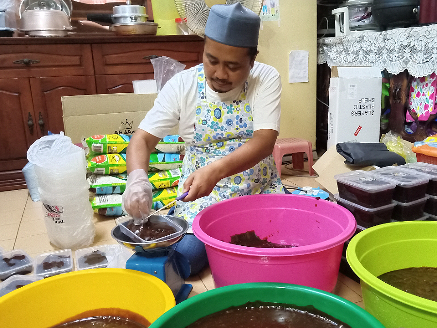 Azman membungkus dodol yang ditempah pelanggannya di kediamannya di Melaka.