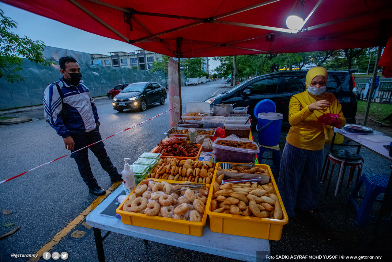 Seorang pelanggan menunggu untuk membeli makanan, selepas operasi kedai makan dan gerai dibenarkan beroperasi mulai 6 pagi hingga 10 malam.