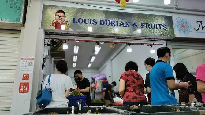 Orang ramai mendapatkan makanan yang disumbangkan oleh Louis di kedainya di Owen Road.