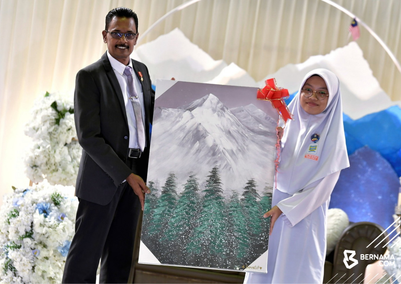 Pengetua Sekolah Menengah Kebangsaan Taman Sri Muda, yang juga bekas pendaki Gunung Everest 1997, Datuk M Magendran (kiri) menerima cenderahati daripada pelajarnya pada Majlis Semarak Budi, Kilauan Bakti sempena persaraannya, semalam. gambar BERNAMA
