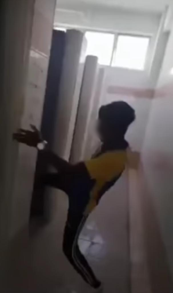 Salah seorang pelajar terbabit turut dirakamkan menendang pintu tandas. - Gambar dari media sosial
