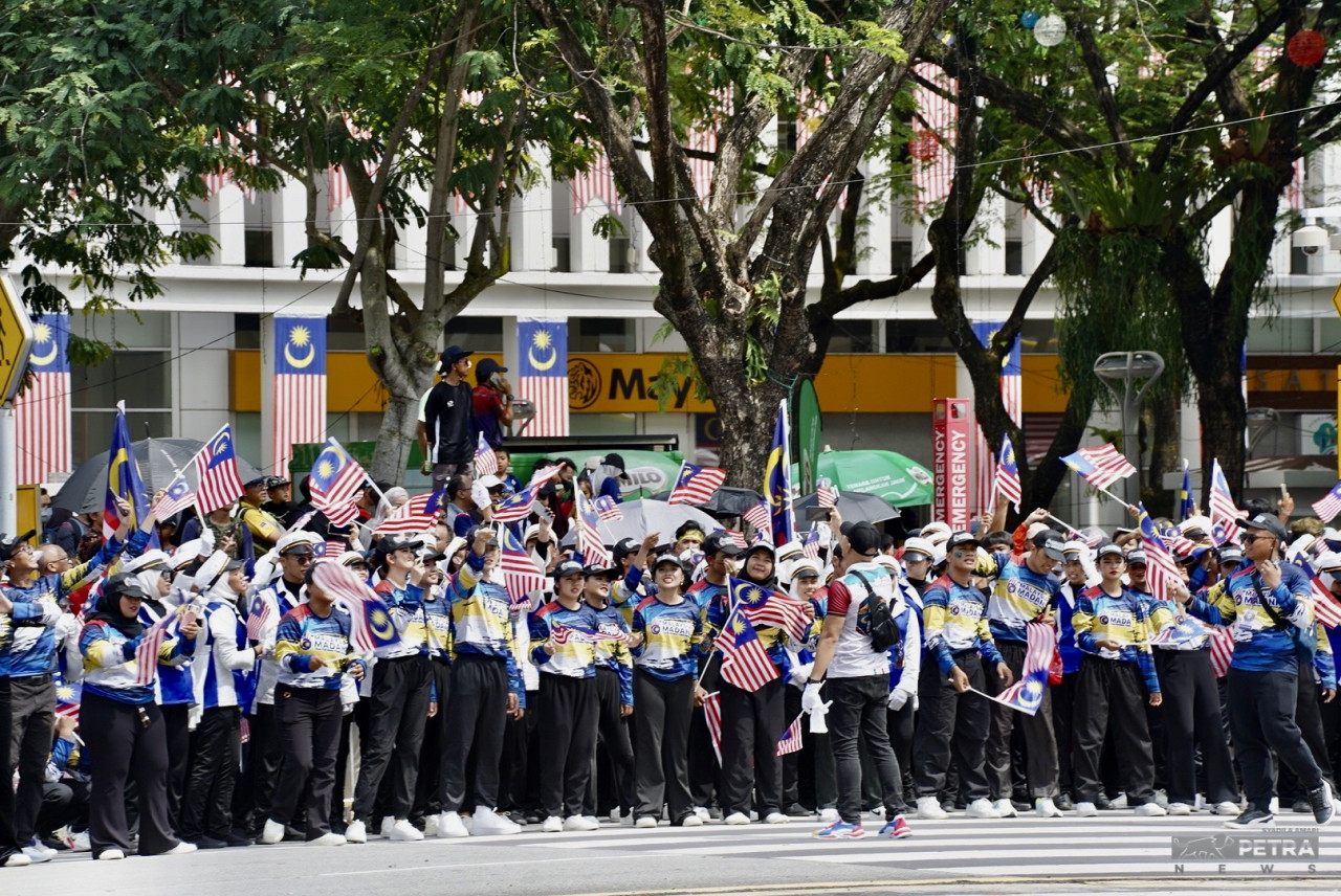 Peserta persembahan mengibarkan Jalur Gemilang di Dataran Putrajaya.