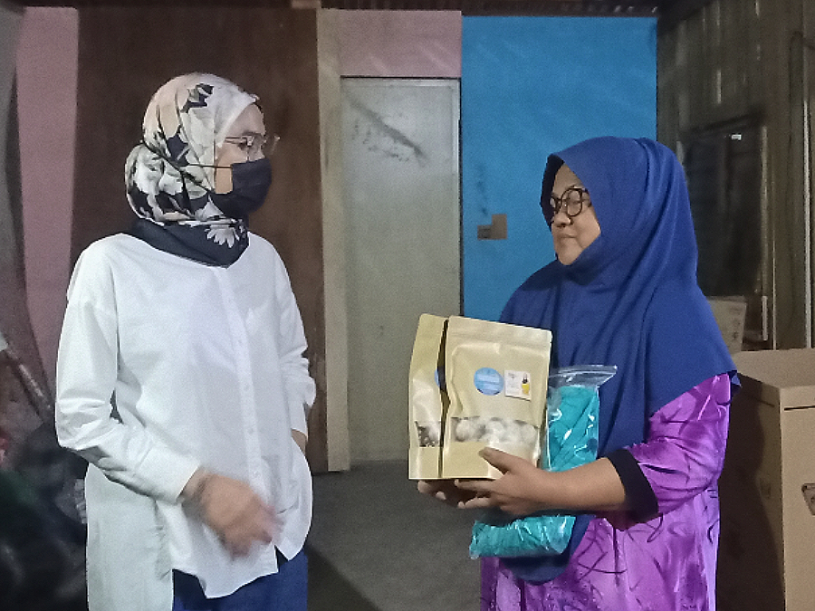 Rina menyampaikan bantuan kepada Sapiah sempena sambutan Aidilfitri di Tawau, baru-baru ini.