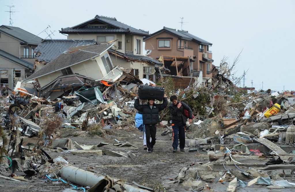 Gambar fail menunjukkan penduduk berpindah selepas rumah mereka hancur dilanda gempa bumi dan tsunami. - Gambar AFP