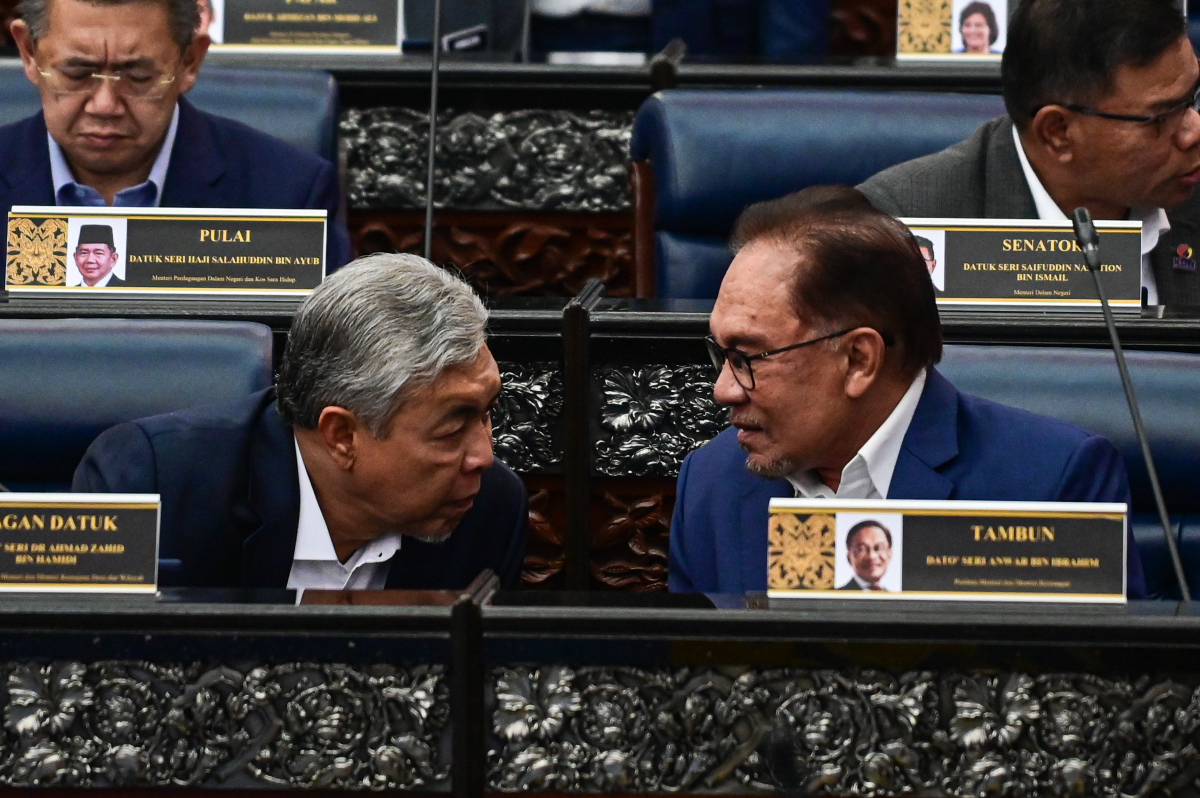 Anwar berbincang dengan timbalannya, Datuk Seri Dr Ahmad Zahid Hamidi pada sidang Dewan Rakyat hari ini. - Gambar dari Jabatan Penerangan