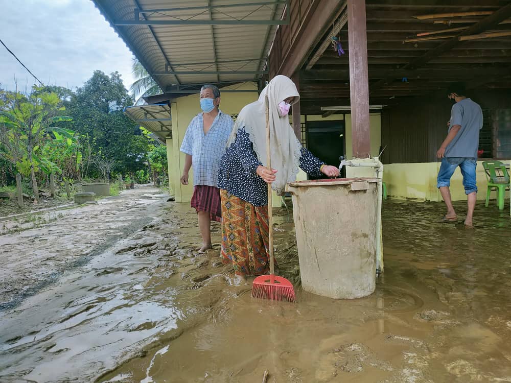 Zaitun dibantu abangnya, Abd. Wahab Abdullah, 73, membersihkan rumah mereka di Seberang Pekan Yan, hari ini.