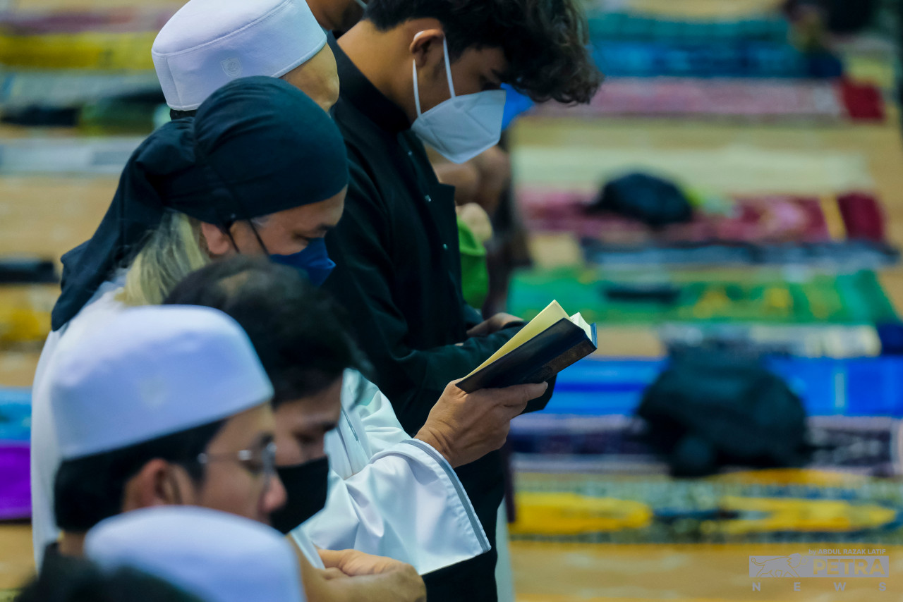 Menggunakan Al-Quran ketika solat sunat tarawih bagi memahami dengan mendalam ayat-ayat yang dibaca oleh imam. - Gambar oleh Abdul Razak Latif