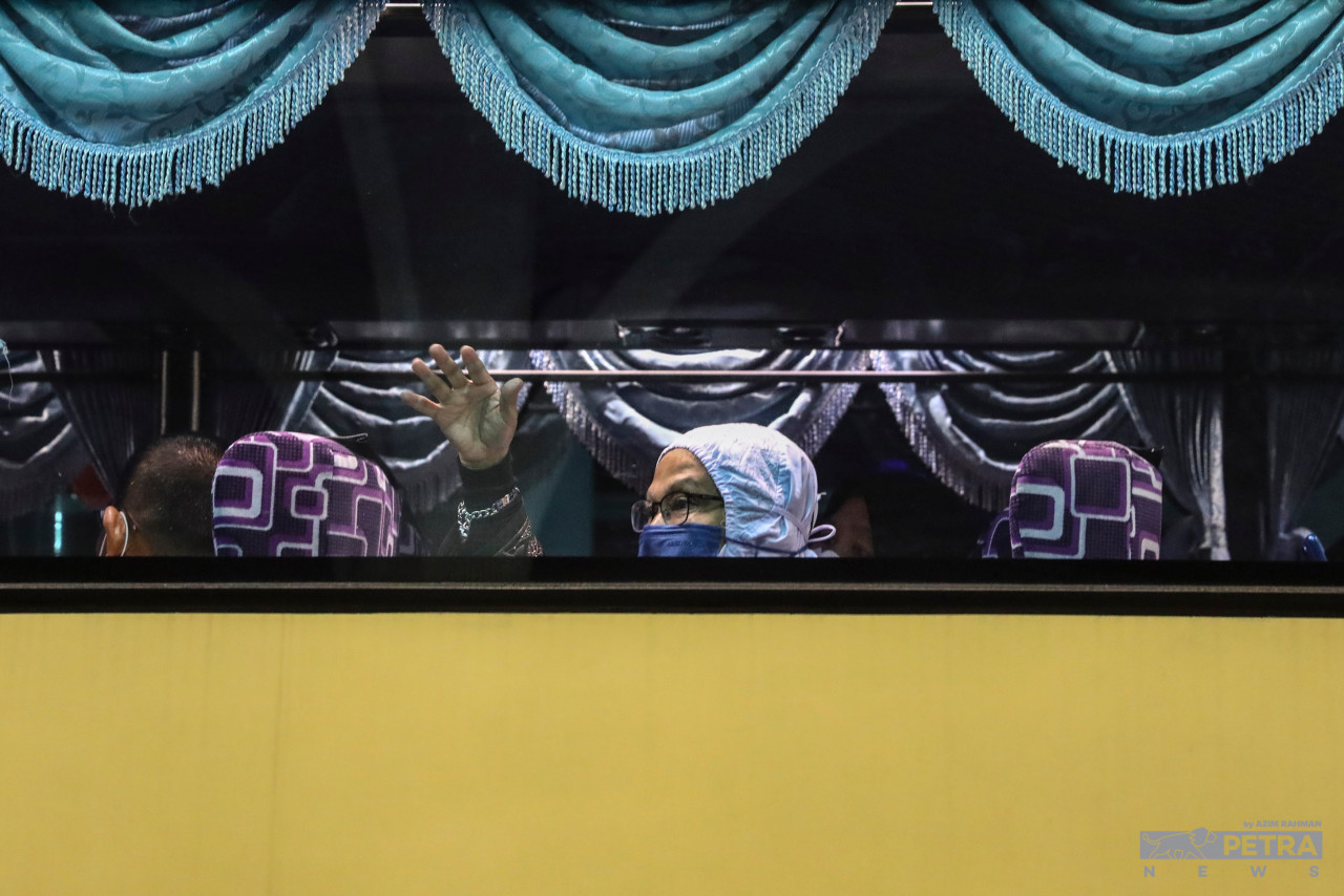Seorang jemaah haji melambaikan tangan kepada sanak saudara di Hotel Mövenpick di Sepang, sebelum dibawa ke KLIA. - Gambar oleh Azim Rahman