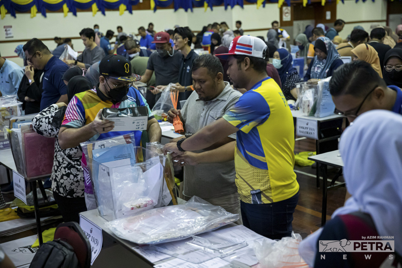 Petugas SPR membuat persiapan peralatan untuk mengundi esok di SK Presint 9(1) Putrajaya. 