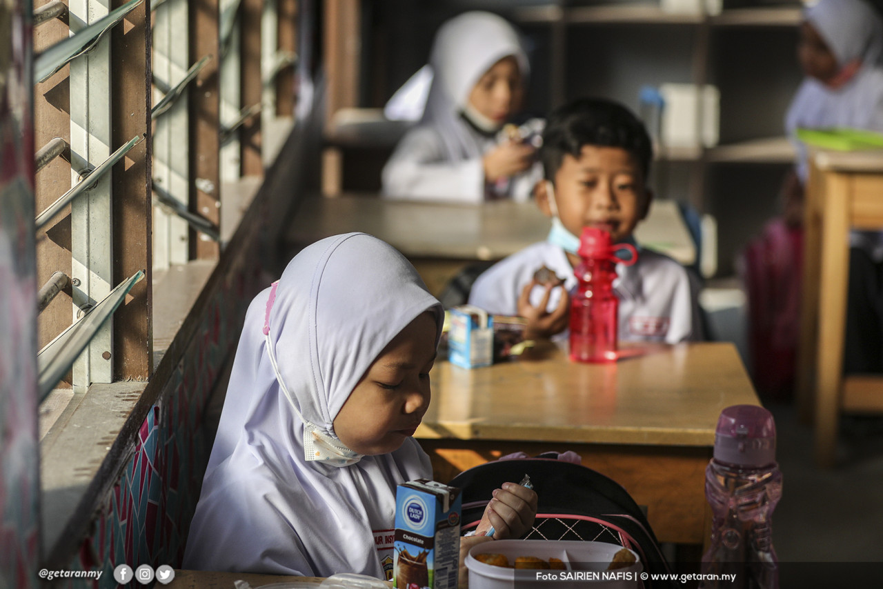 Murid-murid makan di waktu rehat dalam kelas. - Gambar Sairien Nafis