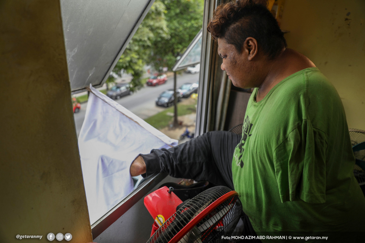 Mohd Nor Abdullah yang tiada kedua-dua tangan sejak lahir meminta bantuan dengan mengibarkan bendera putih di kediamannya di Cheras. - Gambar oleh Azim Rahman