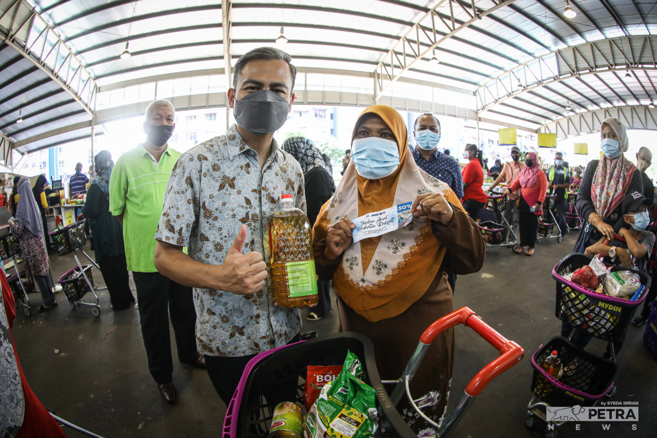Fahmi (kiri) bersama seorang penerima bantuan yang mengunjungi Jualan Amal Prihatin Rakyat Mydin, yang diadakan di  Dewan Terbuka Dataran Seri Angkasa, di sini, hari ini. - Gambar oleh Syeda Imran
