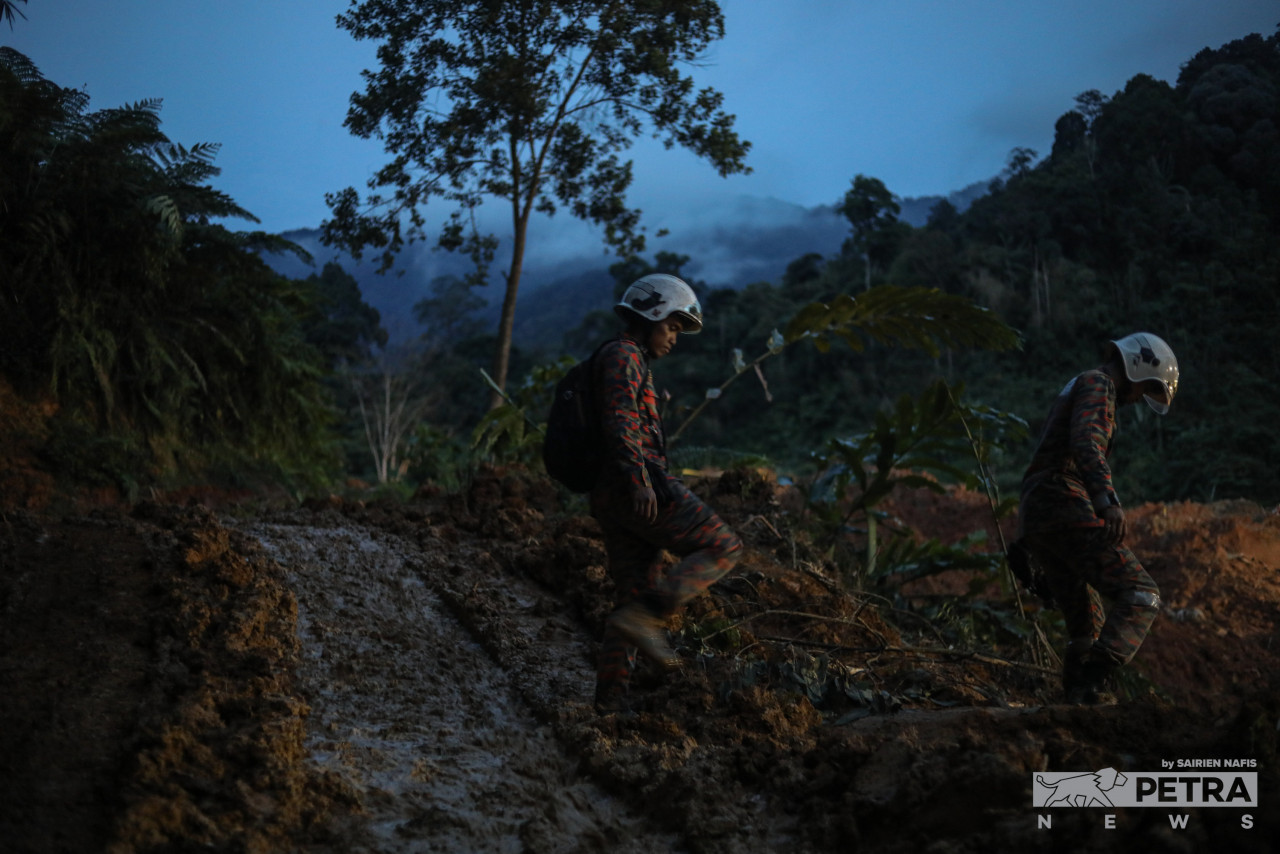 Anggota bomba bergerak ke tapak kejadian tanah runtuh di waktu senja. - Gambar oleh Sairien Nafis