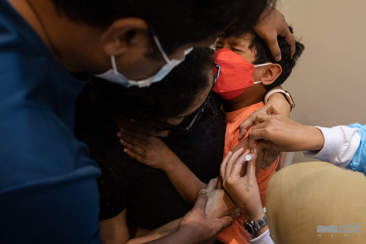 Seorang kanak-kanak lelaki sedang menerima suntikan vaksin COVID-19 sempena program PICKids di WTCKL. - Gambar oleh Sairien Nafis