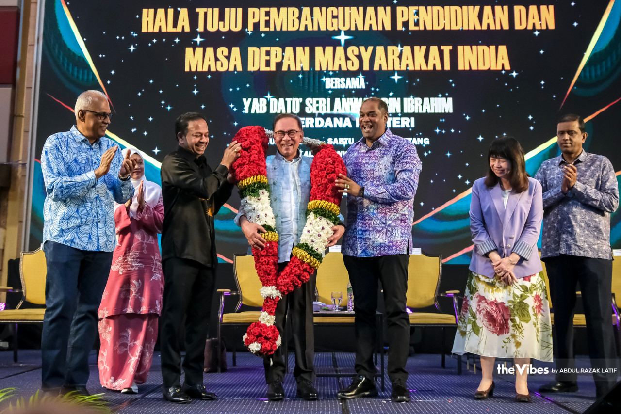 Anwar dikalungkan bunga malai oleh R Ramanan (kanan) dan Vigneswaran (kiri) pada program Hala Tuju Pembangunan Pendidikan dan Masa Depan Masyarakat India bersama Perdana Menteri di sini, hari ini. - Gambar oleh Abdul Razak Latif