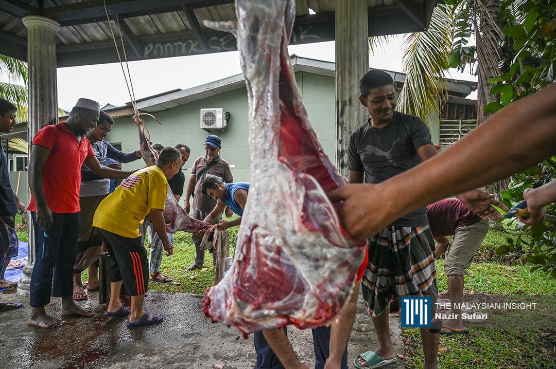 Penduduk tempatan dan pekerja Bangladesh saling bekerjasama melapah lembu untuk menyiapkan juadah berbuka puasa di Masjid Al Azim, Nilai, Negeri Sembilan
