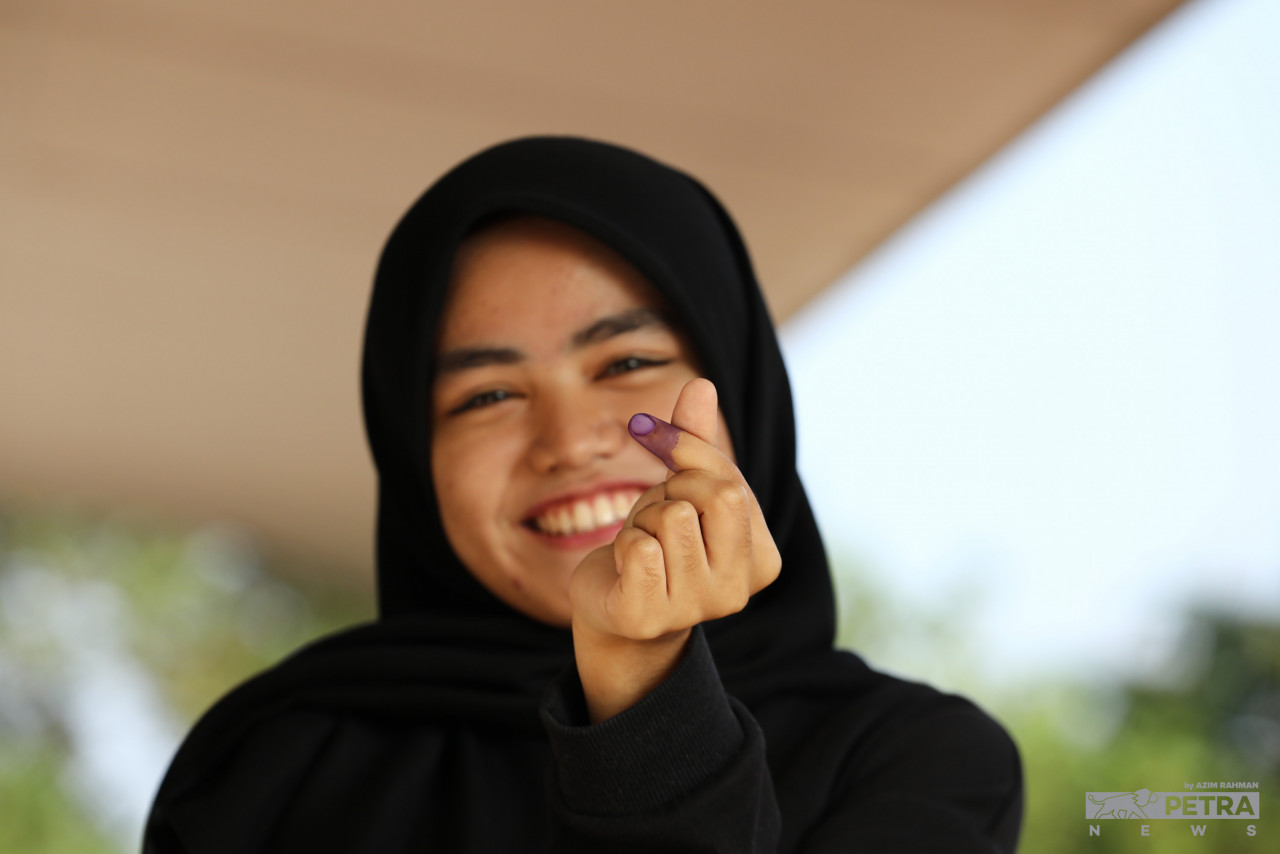 Nadia Nur Aishah Abdull Manan, 18, menunjukkan jari yang dicalit dakwat kekal selepas membuang undi sempena PRN Johor di SK Taman Sutera Perling. 