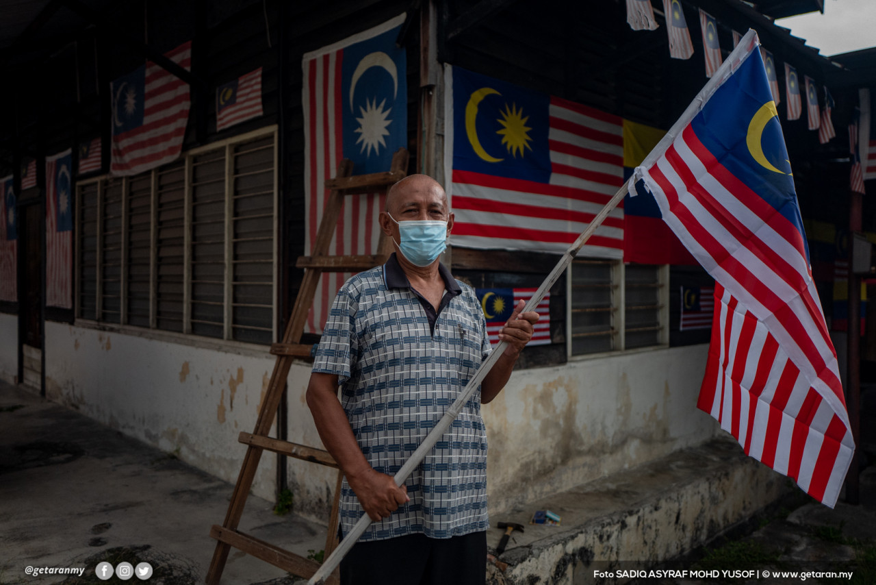 Rifa'i Jalinus, 71, memasang lebih 50 bendera Jalur Gemilang di sekeliling rumahnya sempena Bulan Kemerdekaan di Kampung Baru, Kuala Lumpur - Gambar Sadiq Asyraf