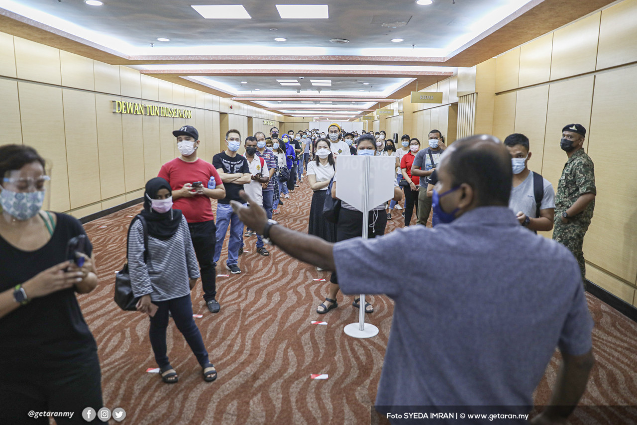 Orang ramai mendengar arahan daripada pegawai bertugas di PPV WTCKL. - Gambar oleh Syeda Imran