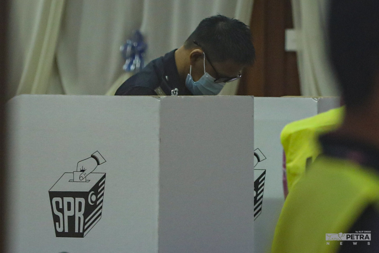 Seorang anggota polis sedang mengundi. - Gambar oleh Alif Omar
