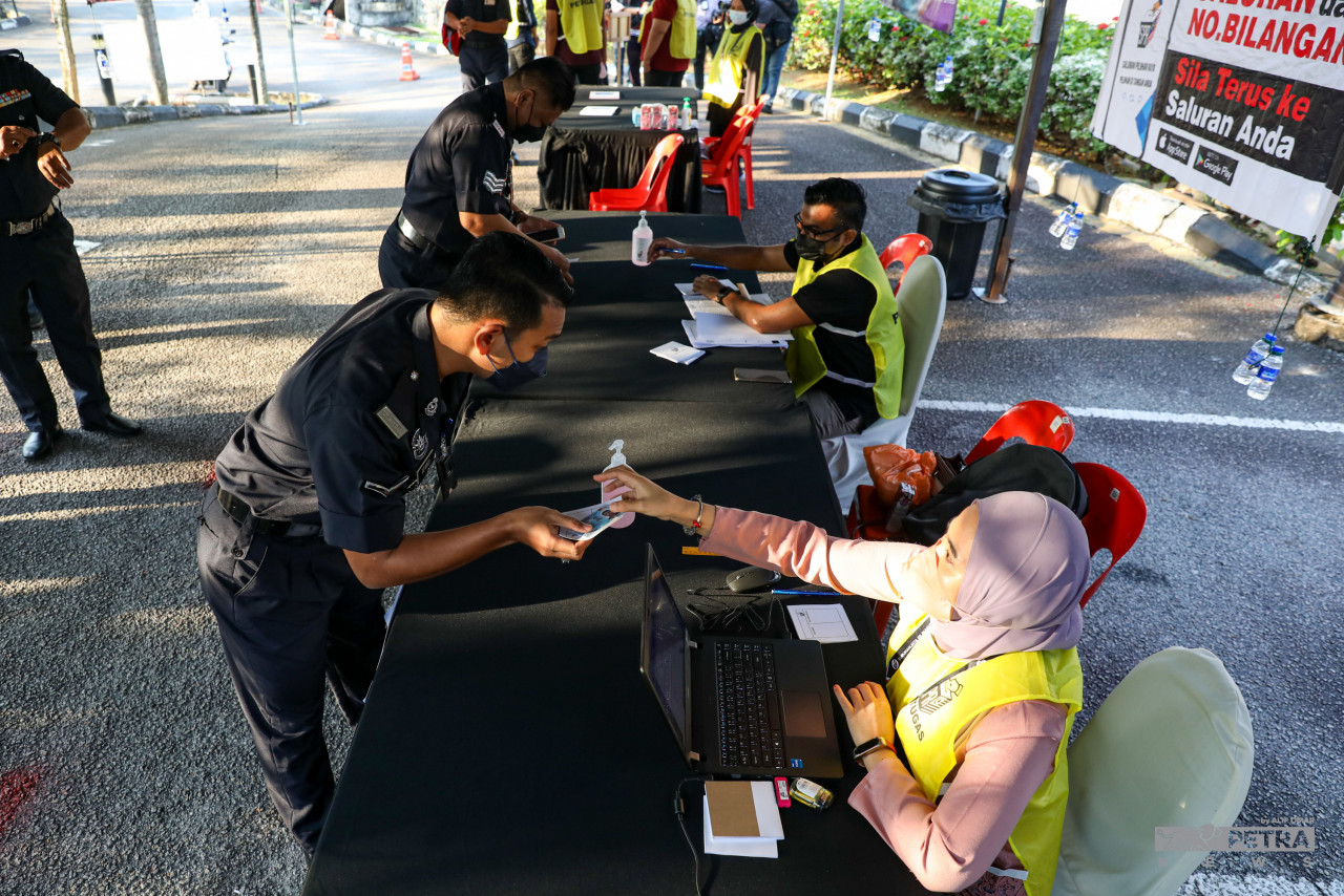Pengundi awal mendaftar sebelum mengundi. - Gambar oleh Alif Omar