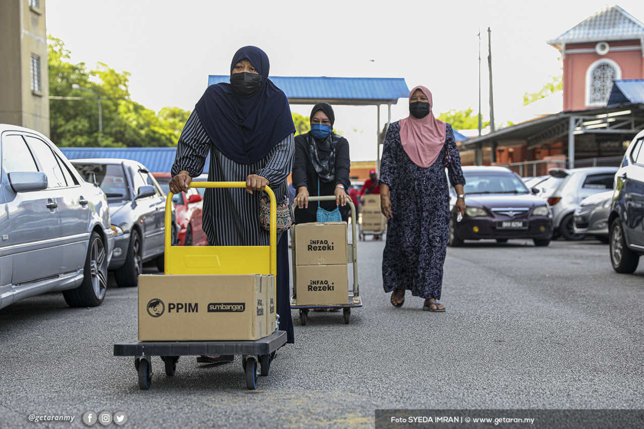 Penduduk PPR Sungai Bunus Keramat membawa sumbangan daripada Yayasan Afdlin Shauki dan PPIM pulang. - Gambar oleh Syeda Imran