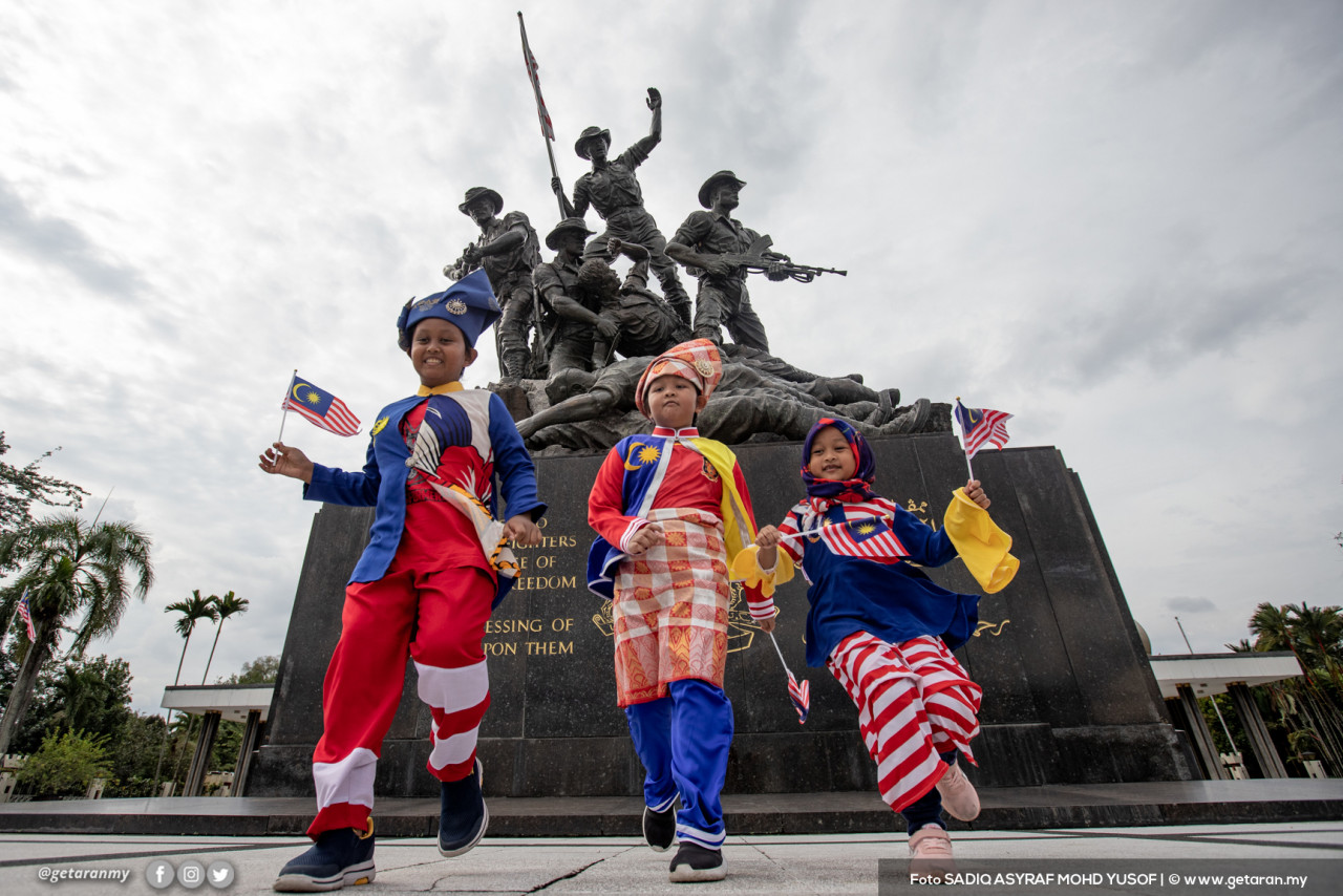 Ahmad Najeh Syauqi, 12 dan adik-adiknya Ahmad Najid Saufi, 9, serta Naa'ilah Sofiyyah, 5 tahun bergambar penuh bersemangat memakai busana khas di depan Tugu Negara. - Gambar Sadiq Asyraf