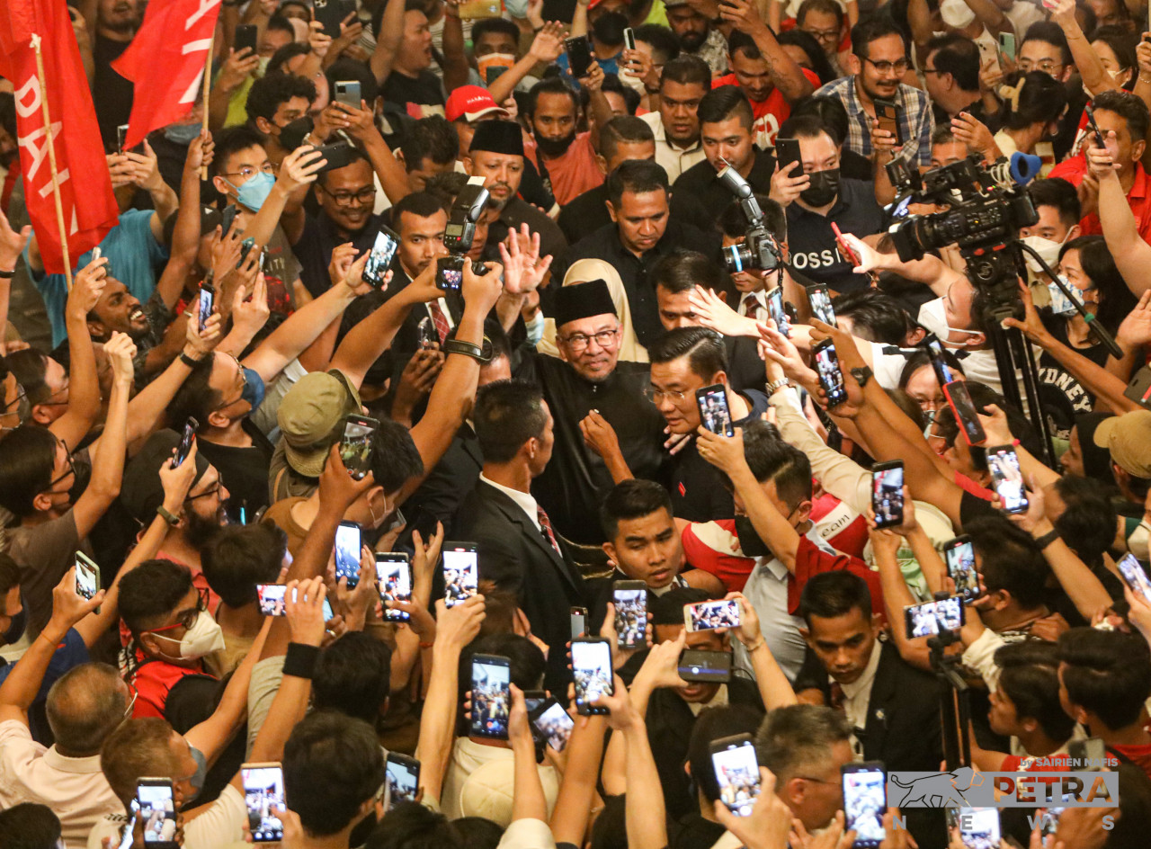 Anwar dikerumuni penyokong ketika tiba di sidang media di Sungai Long Golf and Country Club. - Gambar oleh Sairien Nafis