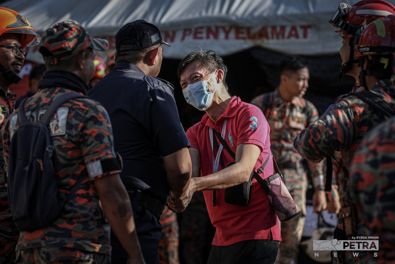 Anggota penyelamat bersalaman selepas berjaya menemui mangsa terakhir tragedi tanah runtuh di tapak perkhemahan Father’s Organic Farm, Batang kali.