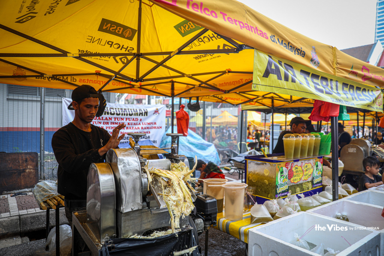Seorang peniaga air tebu menyediakan minuman itu di bazaar ramadan TTDI. - Gambar oleh Syeda Imran