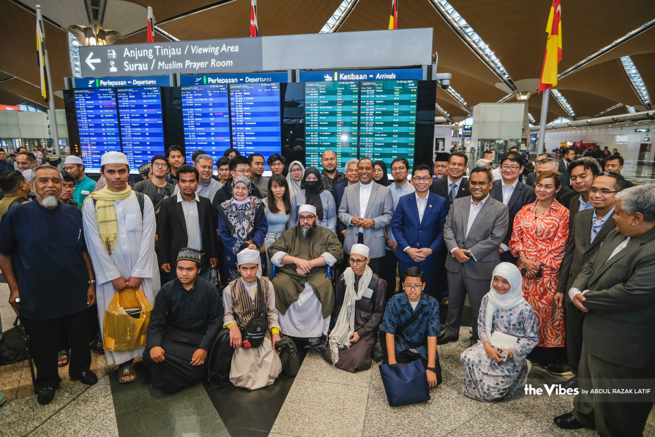 Menteri Luar, Datuk Seri Dr Zambry Abdul Kadir (tengah) bergambar bersama-sama 30 rakyat Malaysia yang tiba dari Sudan, di KLIA, semalam. 