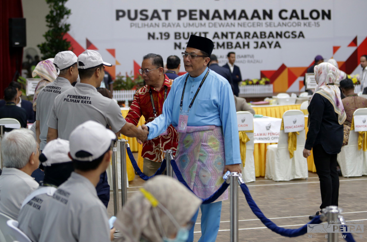 Calon PH di DUN Bukit Antarabangsa, Mohd Kamri Kamaruddin (kanan) bersalaman dengan petugas di pusat pencalonan