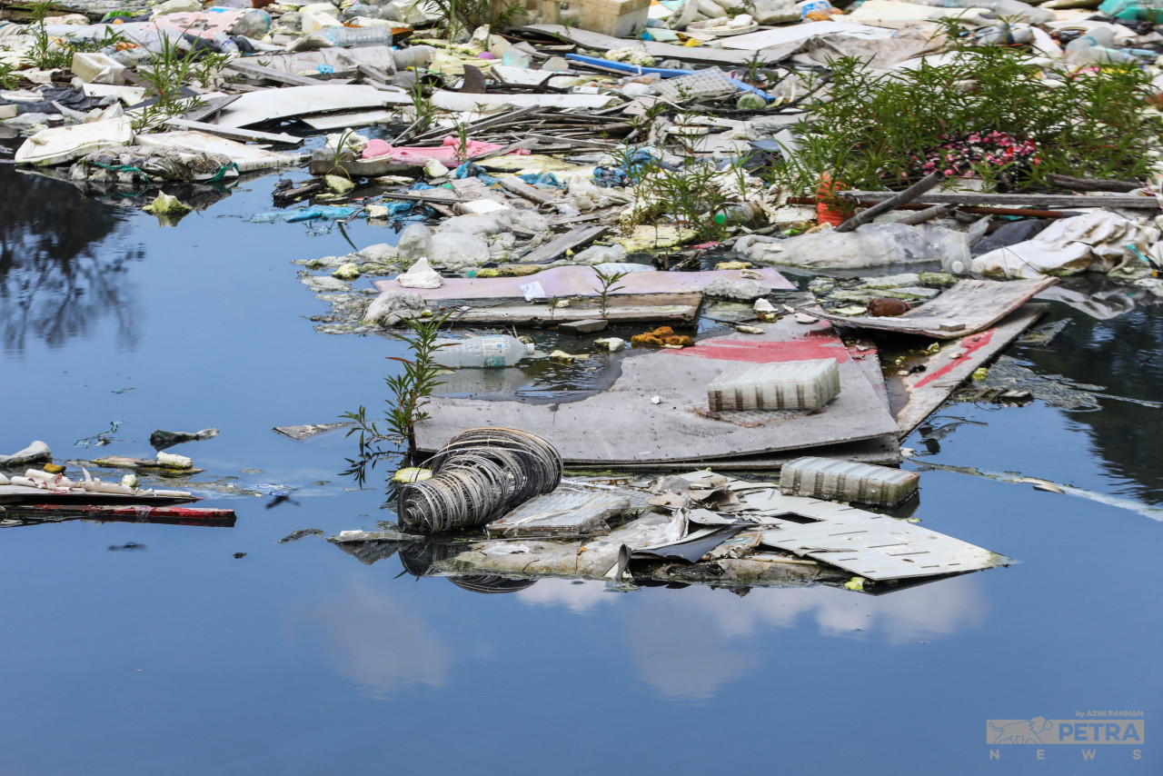 Sampah sarap yang dibuang secara haram terapung di permukaan tasik. - Gambar oleh Azim Rahman