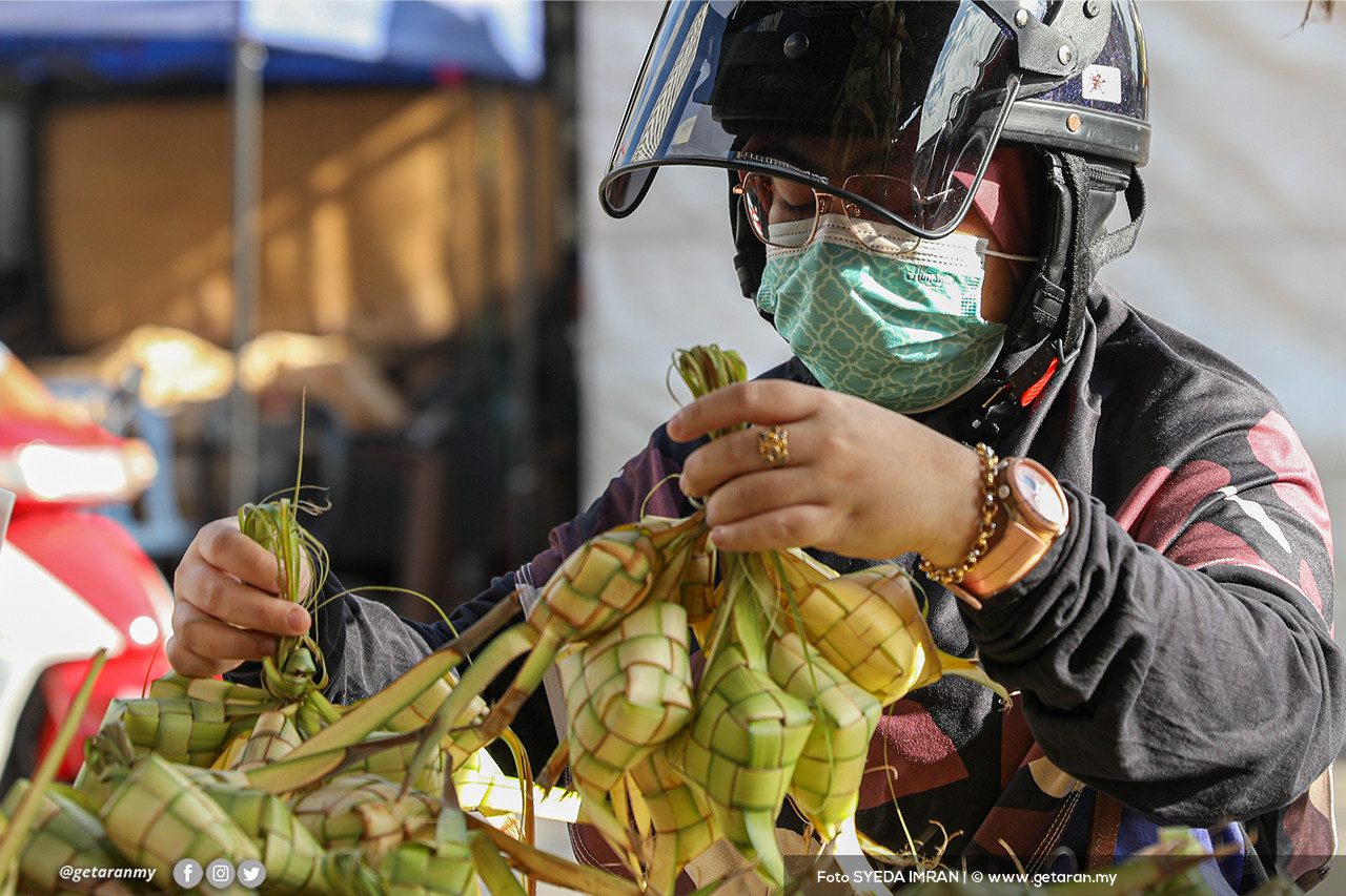 Seorang pelanggan sedang memilih ketupat nasi menjelang Hari Raya Aidiladha esok.