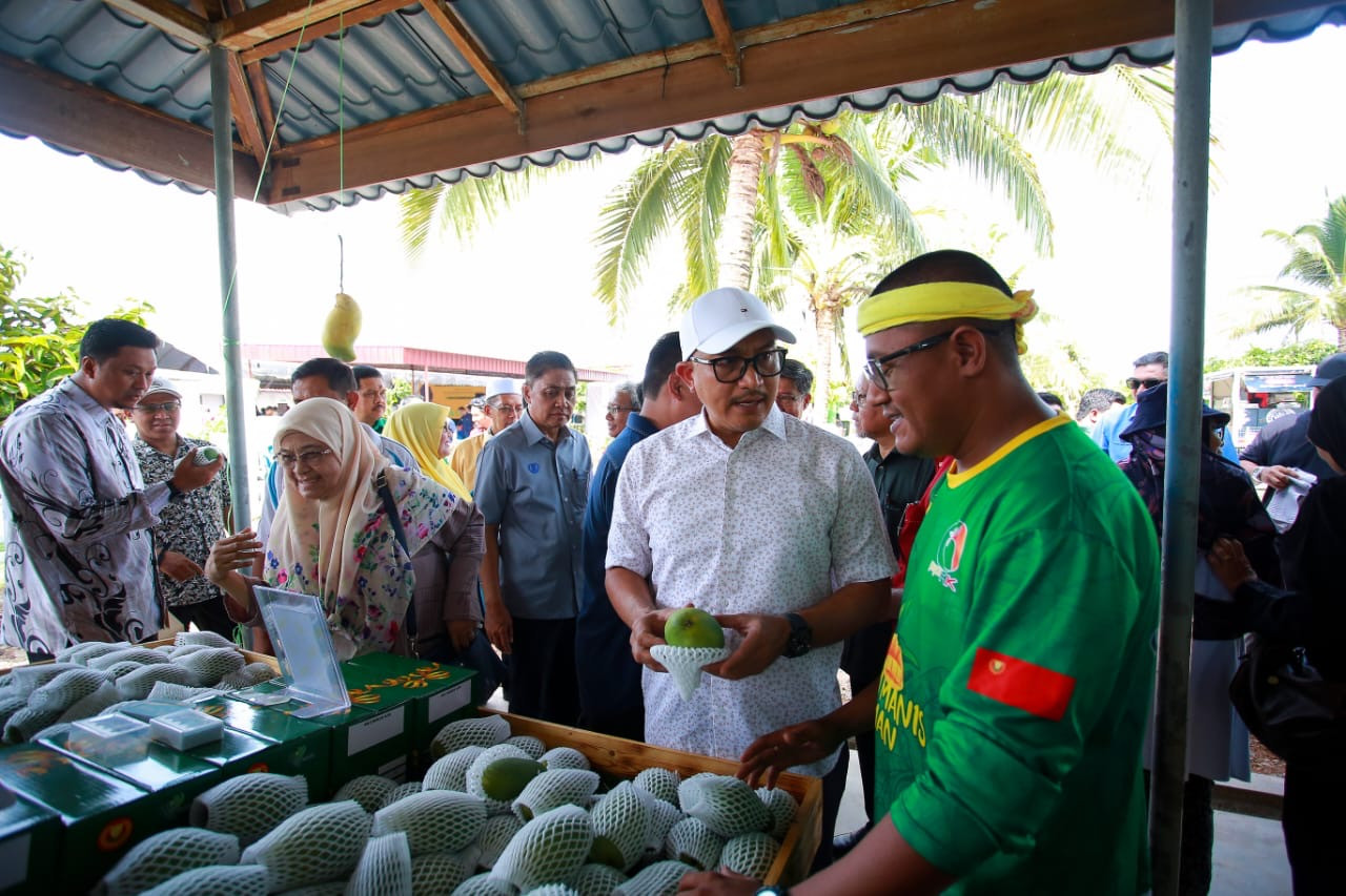 Mohd Salleh Saidin (dua, kanan) berbual bersama seorang pengusaha mangga - gambar Rafisqi Radhi