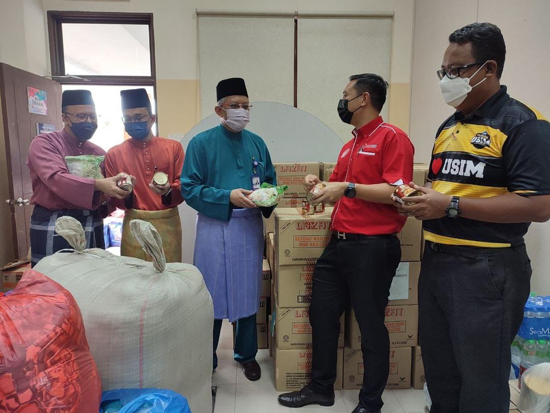 Mohamed Ridza (tengah) mendengar penerangan produk yang disumbangkan Adabi daripada Syed Mahadzir (dua kanan). - Gambar ihsan USIM