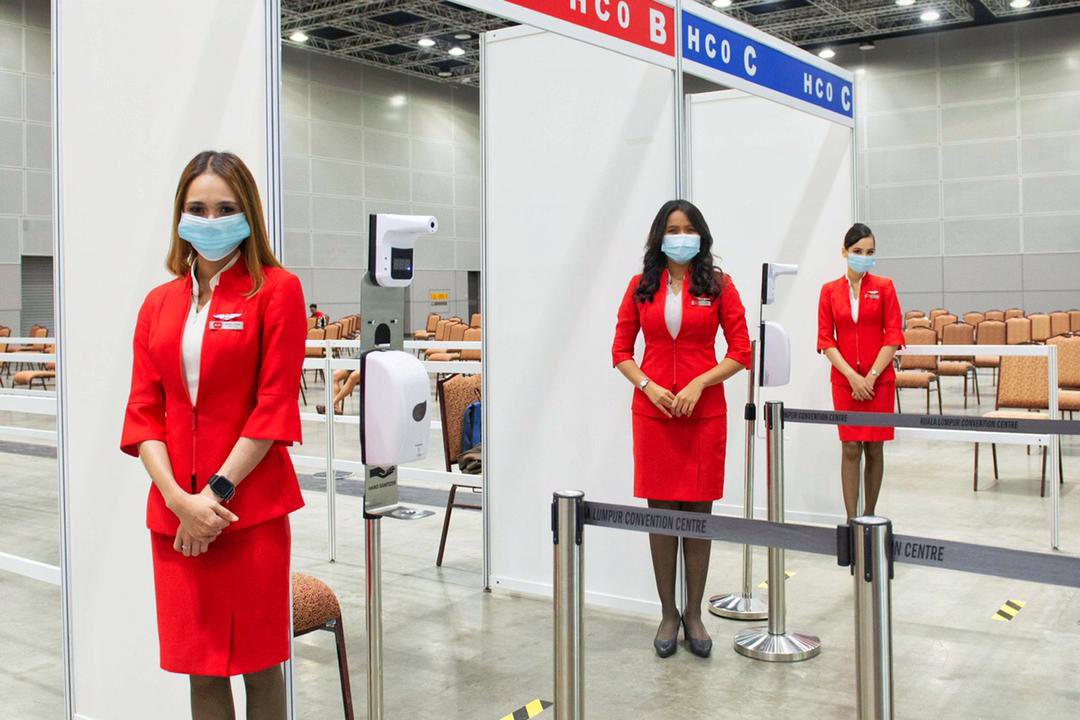 AirAsia Allstars menjaga pintu masuk stesen penerimaan vaksin di PPV Pusat Konvensyen Kuala Lumpur. - Gambar oleh Bernama