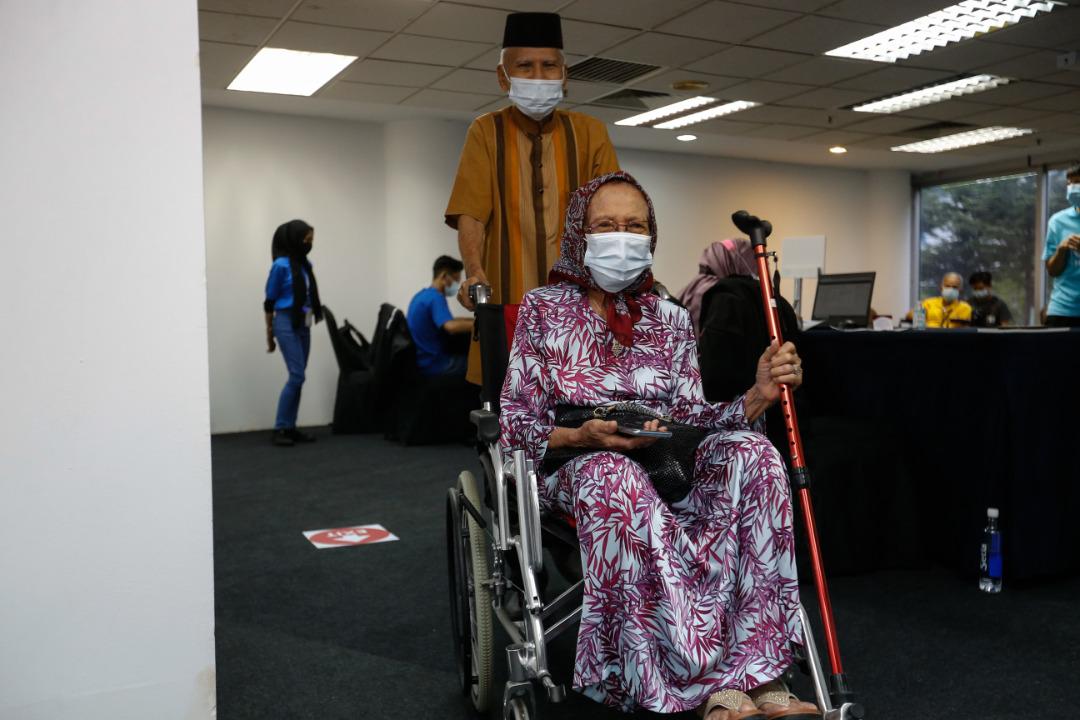 Arifin (berdiri) menasihatkan warga emas supaya tidak takut dan mendengar saranan mengenai vaksin daripada mereka yang pakar.