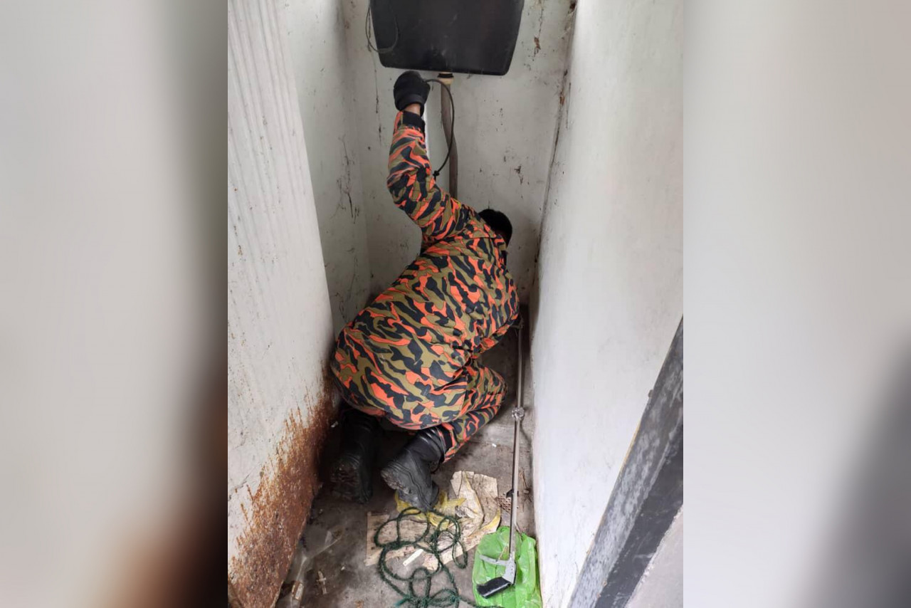 Seorang anggota bomba menjalankan khidmat khas mengeluarkan anak anjing terperangkap dalam lubang tandas.