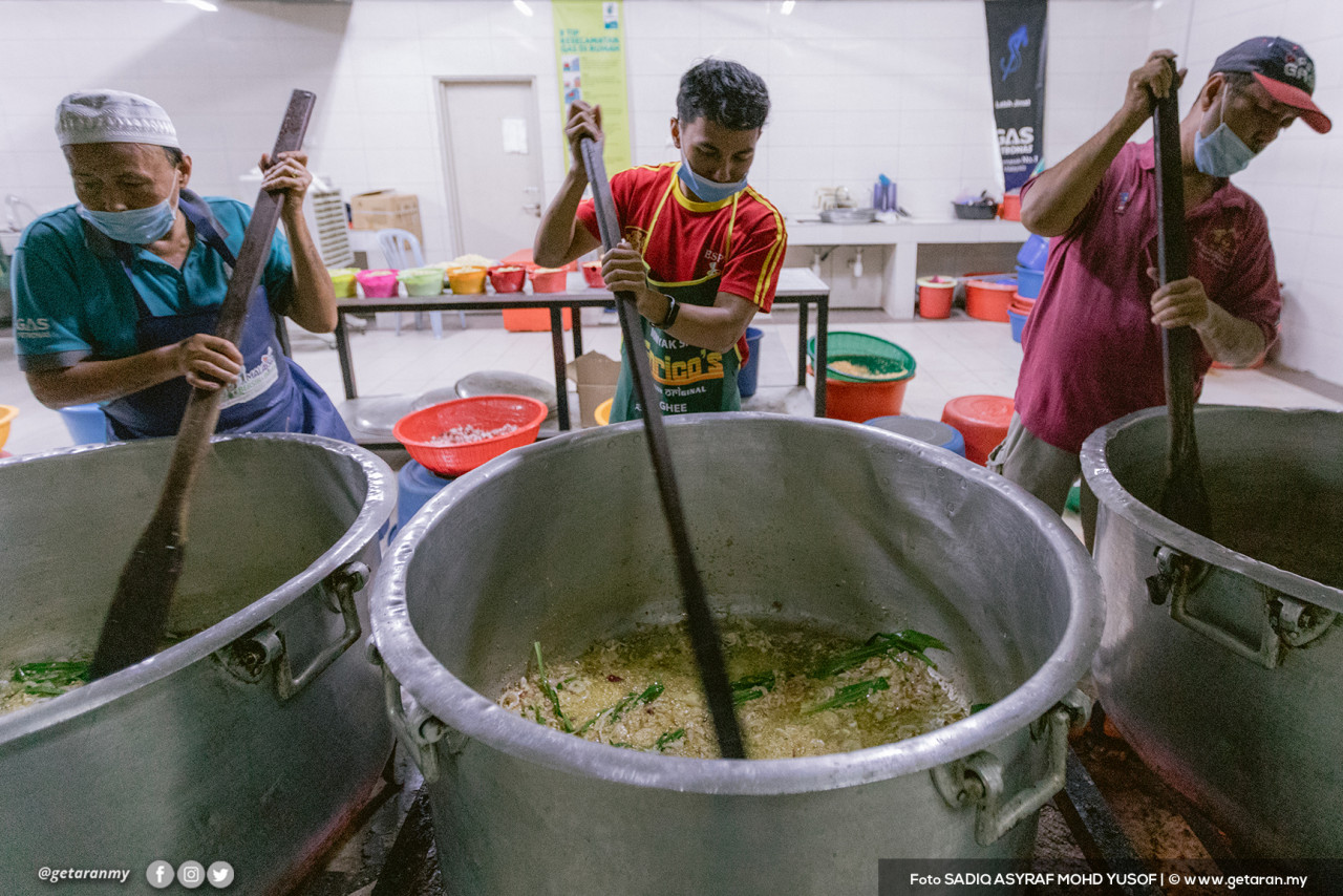 Sukarelawan memasak bubur lambuk. - Gambar fail 