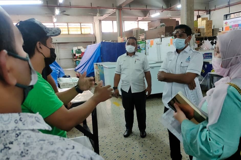 Hamdan (dua dari kanan) mendengar luahan peniaga ikan di Pasar Besar Kuantan ketika meninjau isu berbangkit membabitkan perubahan lot kedai susulan kerja naik taraf pasar berkenaan.
